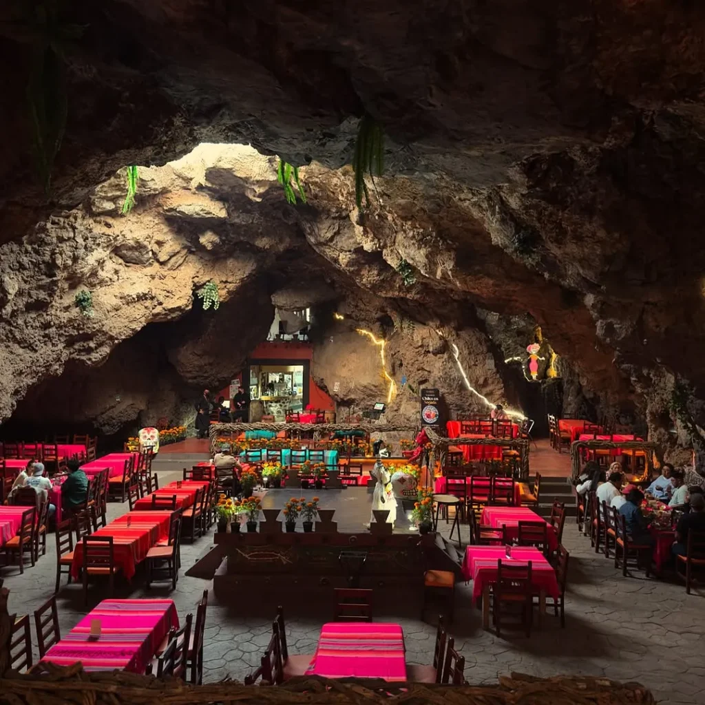 Vuelo en globo Teotihuacán + Desayuno en La Cueva 5 Mesas con manteles rosas y flores de cempasúchil llenan la cueva volcánica del restaurante La Cueva en Teotihuacán