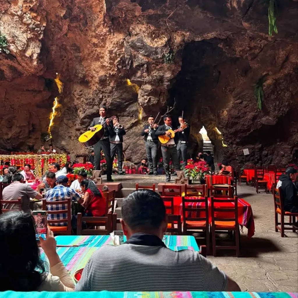 Vuelo en globo Teotihuacán + Desayuno en La Cueva 3 Un mariachi toca en el escenario de piedra mientras los comensales desayunan en el restaurante La Cueva en Teotihuacán