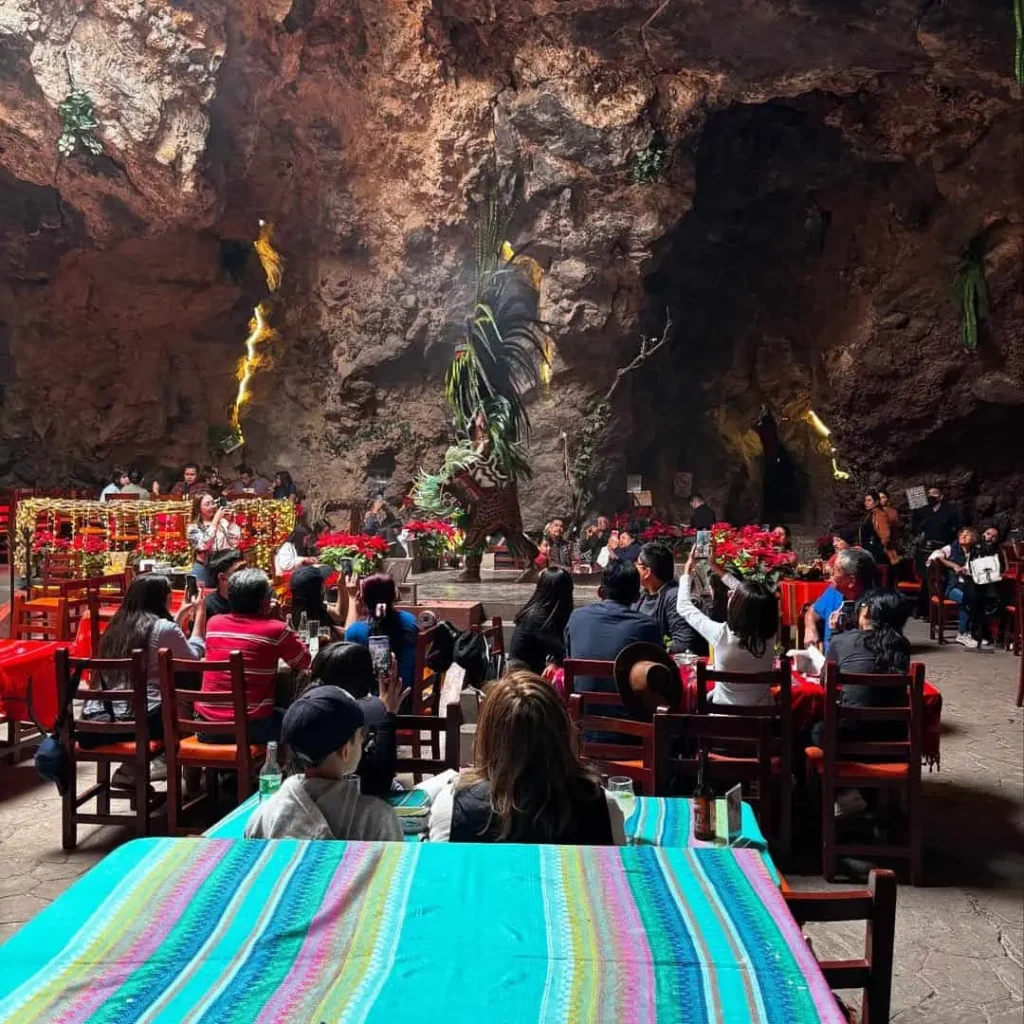 Vuelo en globo Teotihuacán + Desayuno en La Cueva 4 Manteles de sarape turquesa visten las mesas frente al escenario del restaurante La Cueva en Teotihuacán