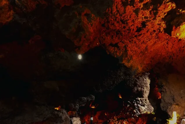 Decenas de mesas con mantel blanco llenan el comedor bajo la bóveda de roca del restaurante La Gruta en Teotihuacán