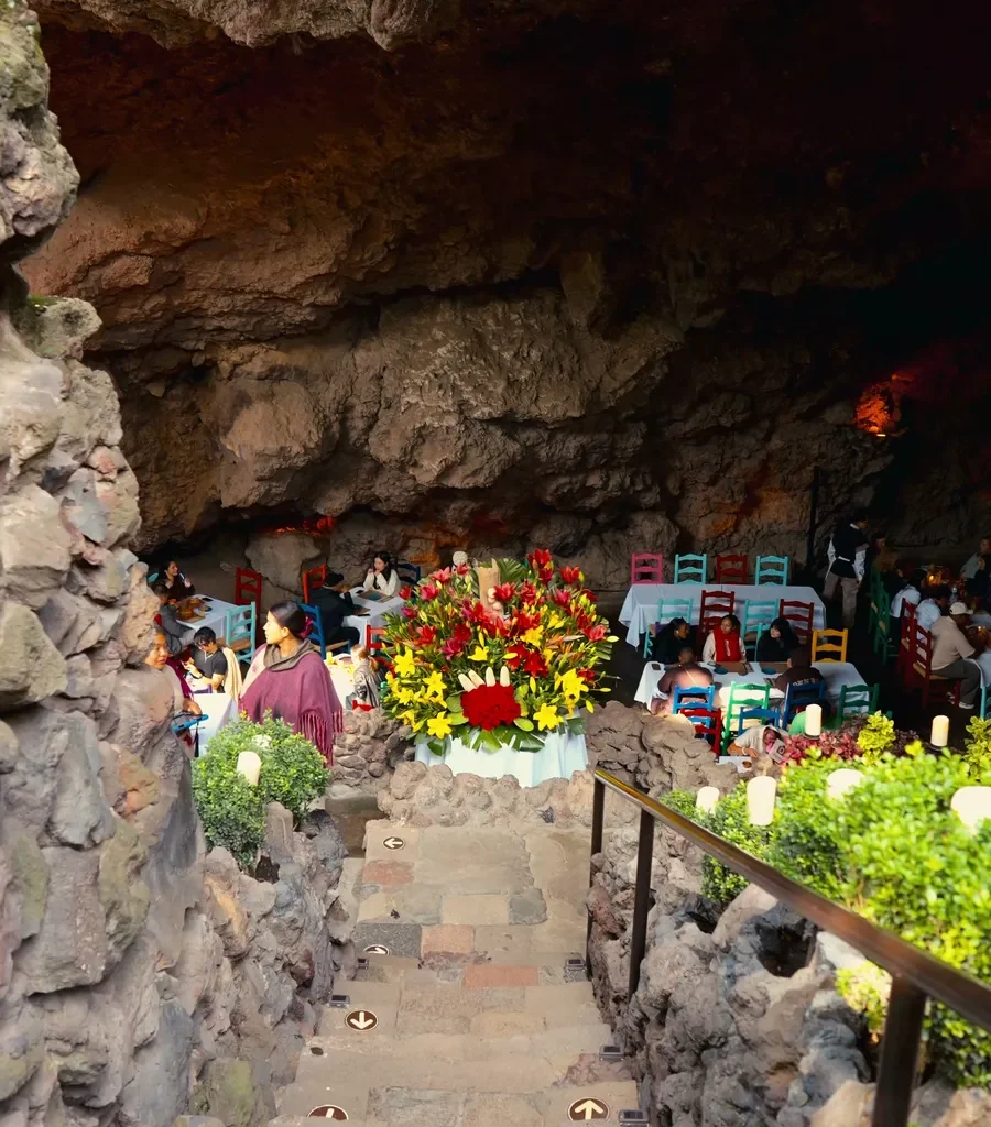 Vuelo en globo Teotihuacán + Desayuno en La Gruta 3 Una escalera de piedra con flores y velas baja al comedor del restaurante La Gruta en Teotihuacán
